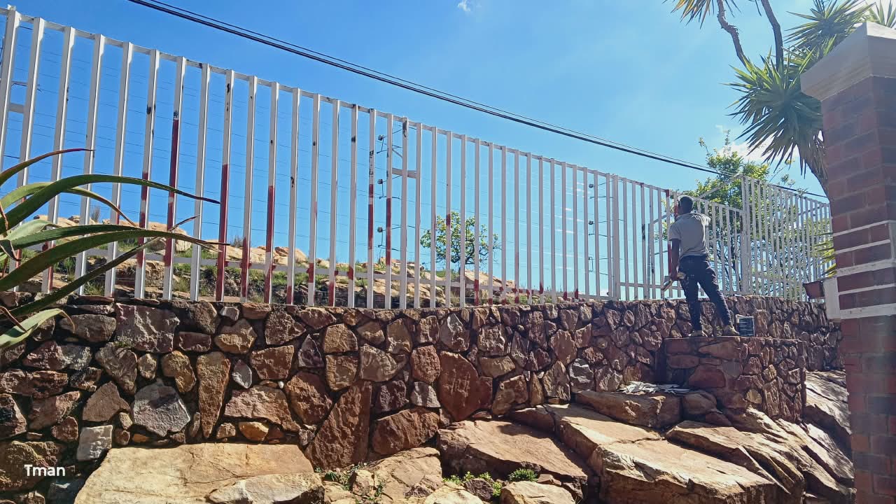 Painting a palisade fence, T. Handyman and Maintenance, Johannesburg